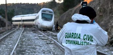 Un agente de la Guardia Civil criminalística fotografía el AVE siniestrado en Adamuz, Córdoba