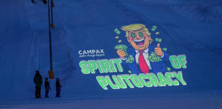 Activistas de la ONG suiza Campax proyectan una caricatura de Trump sobre la nieve durante el Foro de Davos