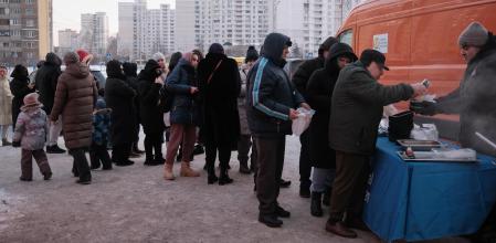 Miles de ucranianos hacen cola a diario para un plato de comida caliente ante las cocinas de la oenegé World Central Kitchen en Kyiv