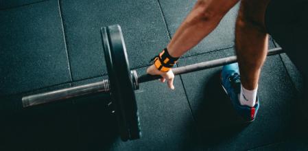 Un hombre levantando una barra de pesas