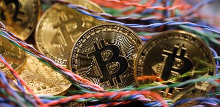 FILE: Bitcoins sit among twisted copper wiring inside a communications room at an office in this arranged photograph in London, U.K., on Tuesday, Sept. 5, 2017. Bitcoin is showing no signs of slowing down, the price of the largest cryptocurrency by market value is soaring as it gains greater mainstream attention despite warnings of a bubble in what not everyone agrees is an asset. Our editors select the best archive images on Bitcoin. Photographer: Chris Ratcliffe/Bloomberg