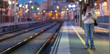 Una joven espera el tren en la estación de la R1 de Badalona durante la caótica reapertura del servicio de Rodalies del 27 de enero