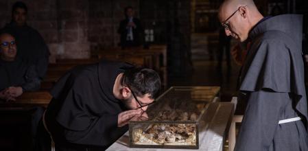 .Dos sacerdotes, ante los restos de San Francisco, en la cripta de la basílica