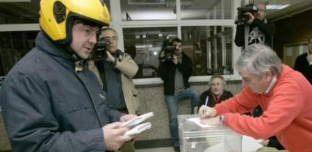 Un cartero hace entrega de votos por correo al presidente de una mesa electoral de Santiago de Compostela durante la jornada electoral en la que los ciudadanos gallegos eligieron el nuevo Parlamento regional