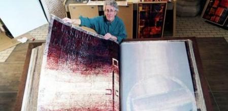 El artista Dieter Gerschler posa con una Biblia gigante en la iglesia St. Johannis Altona en Hamburgo