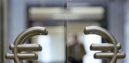 El símbolo del Euro cuelga de los mangos de la puerta de entrada al banco central de Polonia, en Varsovia