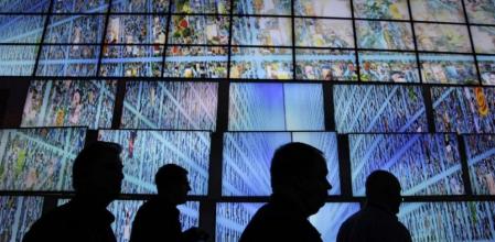 Los expositores y compradores en el Consumer Electronics Show caminan por un despliegue de pantallas de televisión de alta definición de LG, en Las Vegas