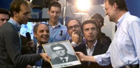 El presidente del PP, Mariano Rajoy (d), recibe ante los presidentes de la Generalitat valenciana, Francisco Camps (3i) y del PP canario, José Manuel Soria (2d), respectivamente, el retrato de su orla de manos de un militante, durante el encuentro que ha mantenido con jóvenes en la zona denominada