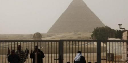 Guías turísticos egipcios y militares aguardan a las puertas de las pirámides de Giza que permanecen cerradas a los turistas