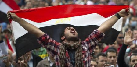 Un opositor a Mubarak grita exultante mientras ondea una bandera egipcia