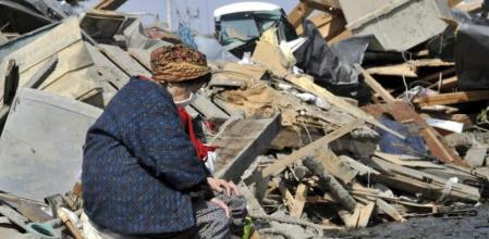 Una anciana sentada entre los escombros en la localidad de Ishinomaki, en la prefectura de Miyagi (Japón)