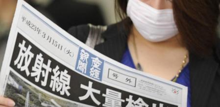 Una mujer con mascarilla lee una edición extra de un diario que anuncia 