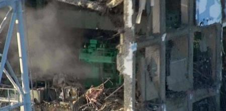 Esta imagen de la destrozada central nuclear de Fukushima difundida por Tokyo Electric Power Co. se puede ver, en la zona central y de color verde, una parte del reactor número 4