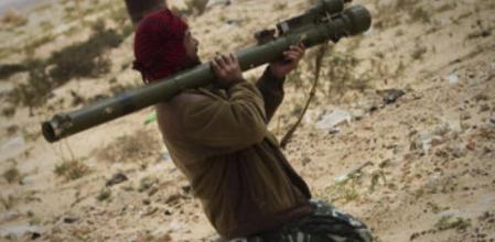 Un rebelde libio apunta a las fuerzas de Gadafi.