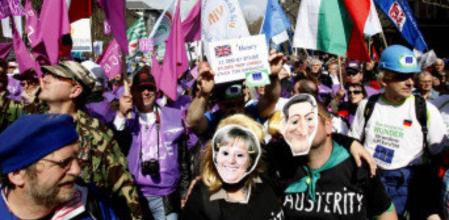 Dos manifestantes portan caretas de Merkel y Sarkozy tras la reunión de ministros de economía en Budapest