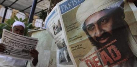 Un paquistaní lee un periódico en Karachi (Pakistán) anunciando la noticia sobre la muerte de Osama Bin Laden.