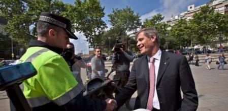 Fernández Díaz saluda a un policía de la Guardia Urbana durante un acto electoral