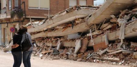 Dos mujeres se lamentan ante uno de los edificios derruidos por el terremoto quesacudió Lorca el pasado miércoles