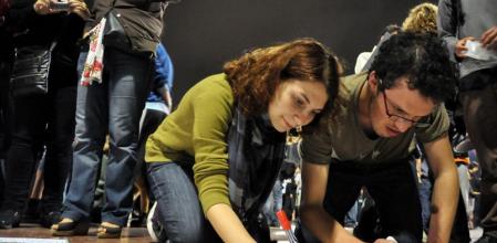 Dos manifestantes escriben pancartas en la acampada de Barcelona (http://www.flickr.com/photos/leyrlo)