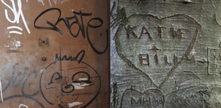 Pintadas y firmas a modo de sello personal en la puerta de acceso a una vivienda