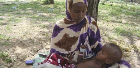 Una mujer del sur de Somalia tiene en sus brazos a un niño que sufre de malnutrición en el campo de refugiados de Mogadiscio, Somalia