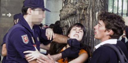 Un policía forcejea con miembros del colectivo de los 