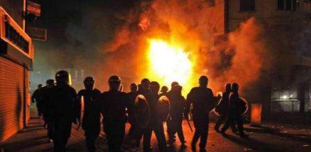 Policías antidisturbios rodean la zona de un edificio incendiado en el barrio de Croydon, al sur de Londres