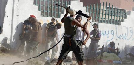 Un rebelde disparando un poco a voleo contra un francotirador gadafista en el barrio de Al Aziziya, donde ayer seguían los combates; Gadafi, escondido, también seguía lanzando llamamientos a 