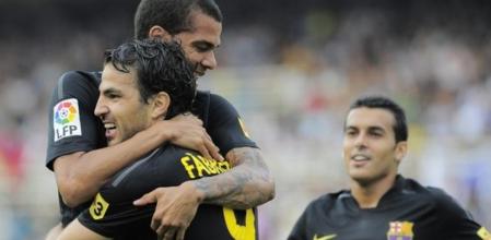 Cesc Fàbregas celebra el segundo gol del Barça ante la Real Sociedad abrazándose a Dani Alves