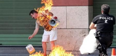 Un policía se apresura a sofocar las llamas de un hombre que se prendió fuego frente a una sucursal bancaria en Salónica, en el norte de Grecia, este viernes. El individuo protestaba contra el gobierno, los bancos y los partidos políticos. El hombre en cuestión, de 55 años, ha intentado quemarse 'a lo bonzo' después de dos años de problemas financieros. El hombre ha sido hospitalizado y su vida corre peligro debido a las quemaduras.