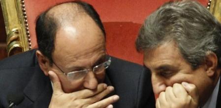 El presidente del Senado italiano, Renato Schifani, se tapa la boca mientras habla con el senador Guido Viceconte.