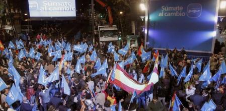 Simpatizantes en las inmediaciones en la sede del Partido Popular, esta tarde en la madrileña calle Génova, para celebrar la posible victoria electoral de los populares en las elecciones generales