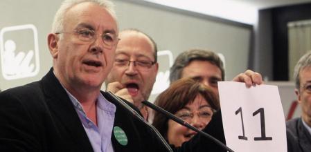 El candidato de IU al Congreso, Cayo Lara, muestra un cartel con los escaños coseguidos en la comparecencia
