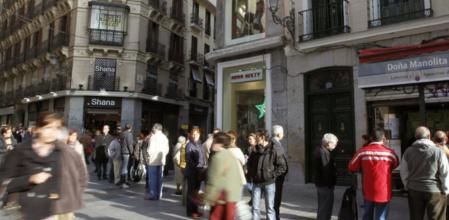 Un grupo de personas hace cola ante la administración de loterías de Doña Manolita, en la calle del Carmen, para comprar décimos para el sorteo extraordinario de Navidad de la Lotería Nacional
