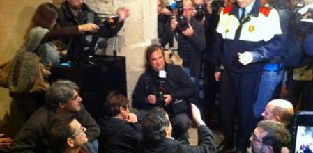 Un mosso entra en la sala donde se han sentado miembros de los sindicatos de la función pública en protesta por los recortes