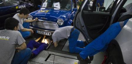 Unos alumnos de un centro de Formación Profesional dedicado a la mecánica de vehículos, en una clase práctica de reparación de averías