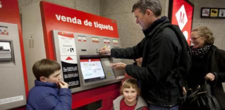 Una familia de turistas australianos compra billetes de metro en la estación de Lesseps, en Barcelona