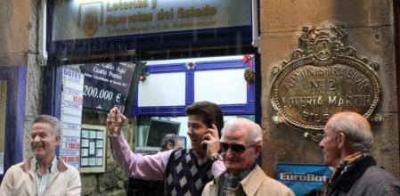 Varios loteros celebran uno de los cuartos premios repartido en la administración número 2 de Bilbao, con el número 12.249, del que han vendido 36 millones de euros