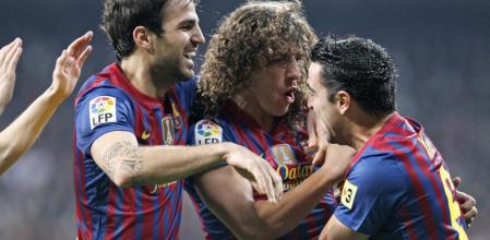 Los jugadores del F. C. Barcelona, Cesc Fábregas, Carles Puyol y Xavi Hernández, celebran el primer gol del equipo blaugrana