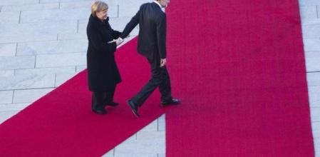 Mariano Rajoy sujeta la mano de Angela Merkel durante una recepción en Berlín