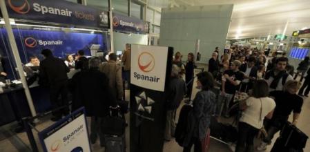 Pasajeros de Spanair en El Prat hacen cola para reclamar sus billetes.
