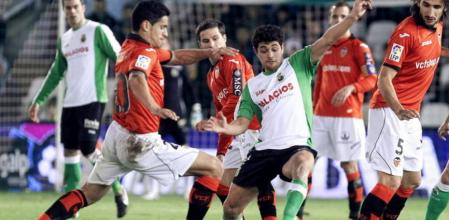 El delantero argentino del Racing de Santander, Lautaro Acosta (c) disputa un balón ante el defensa portugués del Valencia, Ricardo Costa (i) y el centrocampista de su mismo equipo, el turco Mehmet Topal, durante el encuentro, correspondiente a la vigésimo primera jornada de la Liga de Primera División que disputan ambos equipos en el estadio del Sardinero en la capital cántabra