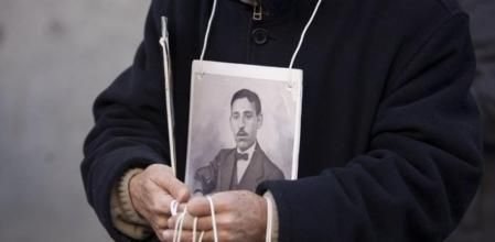 Imagen de un familiar de un represaliado del franquismo portando una fotografía a las puertas del Tribunal Supremo