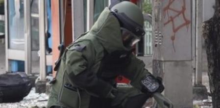 Un artificiero inspecciona la escena del crimen tras la explosión de una bomba al lado de un colegio de Bangkok