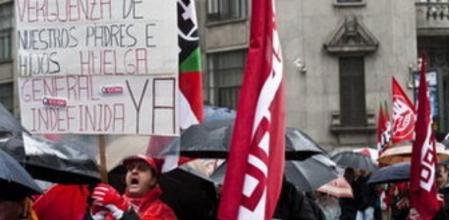 Un hombre porta un cartel llamando a la huelga general indefinida durante la manifestación celebrada hoy, domingo, 19 de febrero de 2012, en Bilbao contra la reforma laboral aprobada por el Gobierno