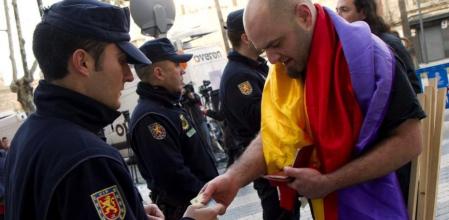 Un policía pide la identificación a un manifestante durante la concentración antimonárquica convocada ante los juzgados de la capital balear por la asociación independentista Maulets, donde el duque de Palma, Iñaki Urdangarin declara hoy como imputado ante el juez del caso Palma Arena, en la pieza que investiga al Instituto Nóos.