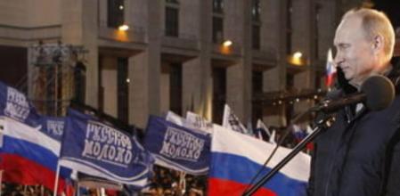 El primer ministro ruso y candidato presidencial, Vladimir Putin, saluda a los seguidores que celebran su victoria en las elecciones presidenciales