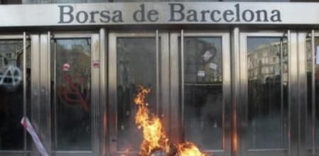 Un piquete de unas mil personas, algunas con los rostros cubiertos ha provocado un pequeño incendio frente a la Bolsa de Barcelona tras realizar pintadas e intentar varias veces derribar sus puerta