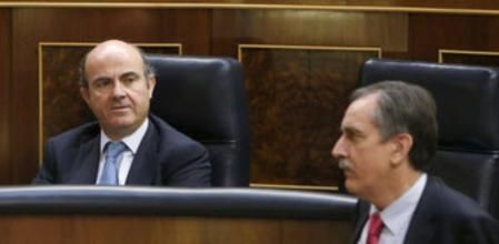El ministro de Economía, Luis de Guindos, y el diputado socialista y exministro de Trabajo y Seguridad Social, Valeriano Gómez, durante la sesión de control al Gobierno