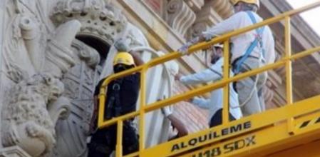 Los operarios trabajan para cubrir el escudo de armas de Felip V con las cuatro barras